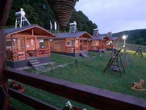 a row of wooden lodges with a playground at Dara's Camping in Prod