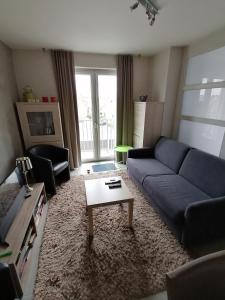 オーステンデにあるApartment Frankyの青いソファとテーブルのあるリビングルーム