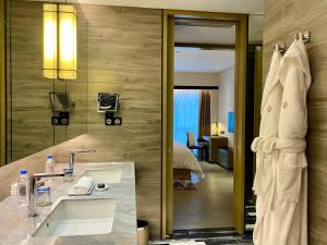 a bathroom with a sink and a mirror at Jumeirah Living Guangzhou-Complimentary Shuttle Bus to Canton Fair Complex during Canton Fair Period in Guangzhou