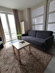 uma sala de estar com um sofá e uma mesa de centro em Apartment Franky em Oostende