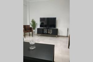 salon z czarnym stołem i telewizorem w obiekcie Arxontia 1 w Kalamácie