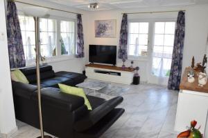 a living room with a couch and a tv at Anna 1 in Grächen