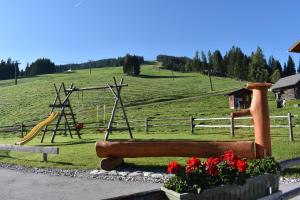 a park with a playground with a slide and flowers at Sonnalm in Altenmarkt im Pongau