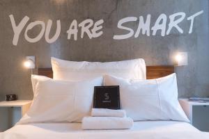 un panneau qui dit que vous êtes intelligent assis sur un lit dans l'établissement Smarthotel Tromsø, à Tromsø