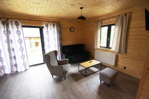 a living room with a couch and chairs and windows at Michałówka Zawoja in Zawoja