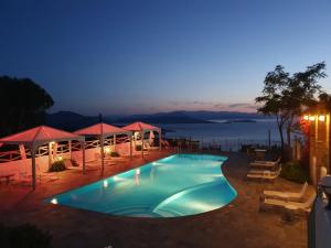 a swimming pool with a view of the ocean at night at Lagou Raxi Country Hotel in Lafkos
