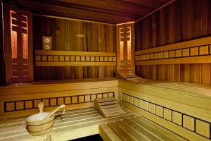 a sauna with a bench and a tub in it at Hotel Kossak in Krakow