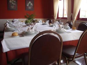 une table avec des assiettes et des verres au-dessus dans l'établissement Hotel Piedra, à Perlora