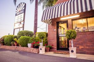 a store front with potted plants in front of it at Country Pathfinder Motor Inn in Dalby