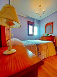 1 dormitorio con 1 cama y 1 mesa con lámpara en Casa Eloy, en Barreiros