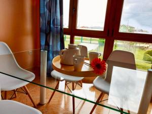 a glass table with chairs and a vase on it at Casa Eloy in Barreiros