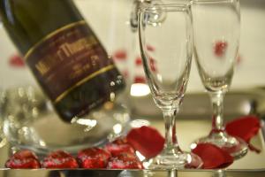 two wine glasses sitting on a table with fruit at Pompei Inn Ruins B&B Luxury Suite in Pompei