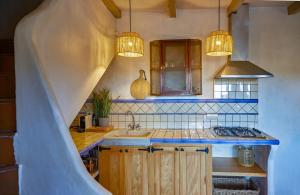 a kitchen with a sink and a stove and lights at Casa Jasmin at Masia Nur Sitges, Adults only in Canyelles