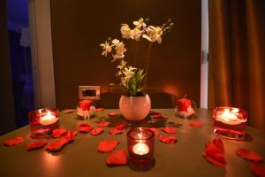 a table with a vase of flowers and candles at Pompei Inn Ruins B&B Luxury Suite in Pompei