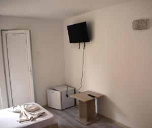 a room with a bed and a television on the wall at Complex Marea Neagra in Eforie Nord