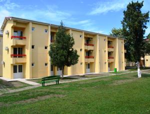 a yellow building with a bench in front of it at Complex Marea Neagra in Eforie Nord