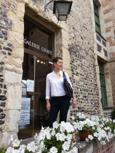 翁弗勒爾的住宿－-La Maison Balancoire - Parking privé offert - Coeur historique -La Clef de Honfleur，站在花房外的人