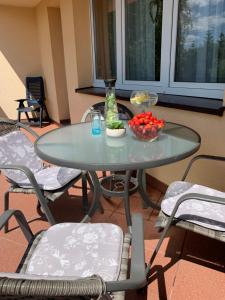 a glass table with a bowl of fruit on a patio at Rytel Zapora 36 in Rytel +5 photos