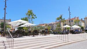 a seating area with tables and chairs and umbrellas at Hotel Relais Du Postillon in Antibes