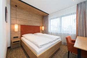 1 dormitorio con cama, mesa y escritorio en Hotel SCHNEIDER en Allersberg