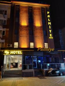 een hotelgebouw 's nachts met een bord erop bij Palmiye Royale Palace in Edirne