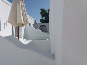 a white building with an umbrella and a window at Sea Wave Hotel in Perissa