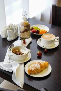 una mesa cubierta con platos de comida y tazas de café en Barkhatnye Sezony Semeiny Kvartal Resort en Adler