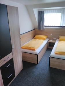 1 Schlafzimmer mit 2 Betten und einem Fenster in der Unterkunft Hotel Rüstersieler Hof in Wilhelmshaven