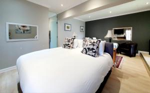 a bedroom with a large white bed with pillows at Two Fat Owls Guesthouse in George