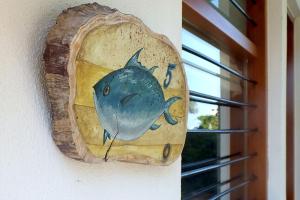 a fish sign on a wall next to a window at 4Elies apartments in Vourvourou