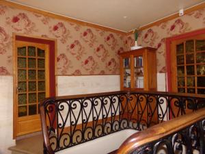 una escalera en una habitación con papel pintado de flores en Chambres d'hotes du Domaine Capiet en Courpiac