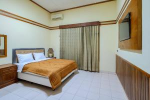 a bedroom with a bed and a television in it at Tobana Pejaten House in Jakarta