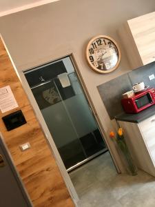un ascensore in cucina con orologio sul muro di HappyHome Appartamento 4 posti letto Rivarolo Canavese a Rivarolo Canavese