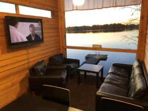 a living room with couches and a flat screen tv at Kyly in Savonlinna
