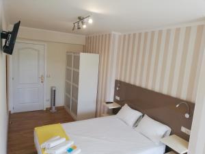 ein Schlafzimmer mit einem weißen Bett mit zwei Handtüchern darauf in der Unterkunft Residencia Compostela in Santiago de Compostela