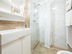 bagno bianco con doccia e lavandino di Appartamento Ai Crocus a Cesclans