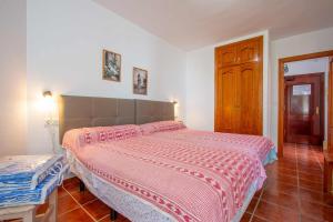- une chambre avec un lit et une couette rouge et blanche dans l'établissement Apartamento en Edificio Torresol, 1ª linea de playa en Nerja, à Nerja