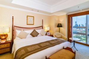 a hotel room with a large bed and a window at Crowne Plaza Qingdao, an IHG Hotel in Qingdao
