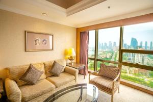 a living room with a couch and a large window at Crowne Plaza Qingdao, an IHG Hotel in Qingdao