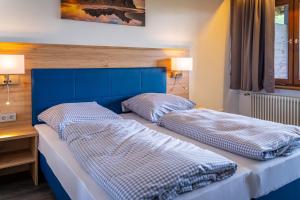 Duas camas num quarto com uma cabeceira azul em Hotel Casa Maria em Halblech