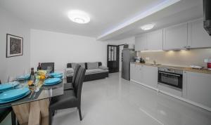 Il comprend une cuisine et un salon avec une table et des chaises. dans l'établissement Apartments The heart of Croatia, à Pirovac