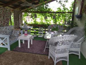 a patio with white wicker chairs and a table and tables at Kvitkovyi Rai in Slavske