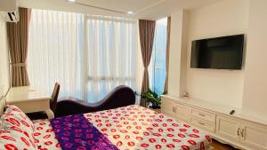 - une chambre avec un lit et une télévision à écran plat dans l'établissement Tropical House, à Hô-Chi-Minh-Ville