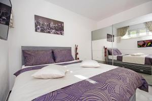 a bedroom with a large bed with purple and white sheets at Villa Inis in Makarska +80 photos