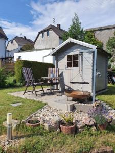 a small shed with a table and chairs in a yard at FeWo Algenrodt in Idar-Oberstein