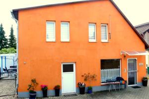 ein orangefarbenes Gebäude mit einer weißen Tür und Fenstern in der Unterkunft Ferienhaus "Harzblick" in Halberstadt