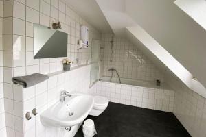 a white bathroom with a sink and a toilet at Moderne und sehr zentral gelegene Apartments in Neuss
