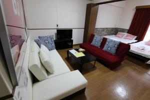 - un salon avec un canapé et une chaise dans l'établissement Laforet Tokaichi, à Hiroshima