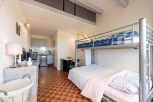 a bedroom with a bunk bed and a bathroom at La Dune in Leucate