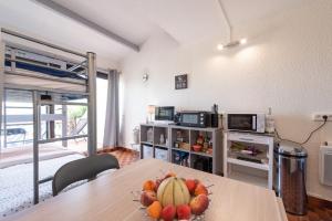 a room with a table with a bowl of fruit on it at La Dune in Leucate